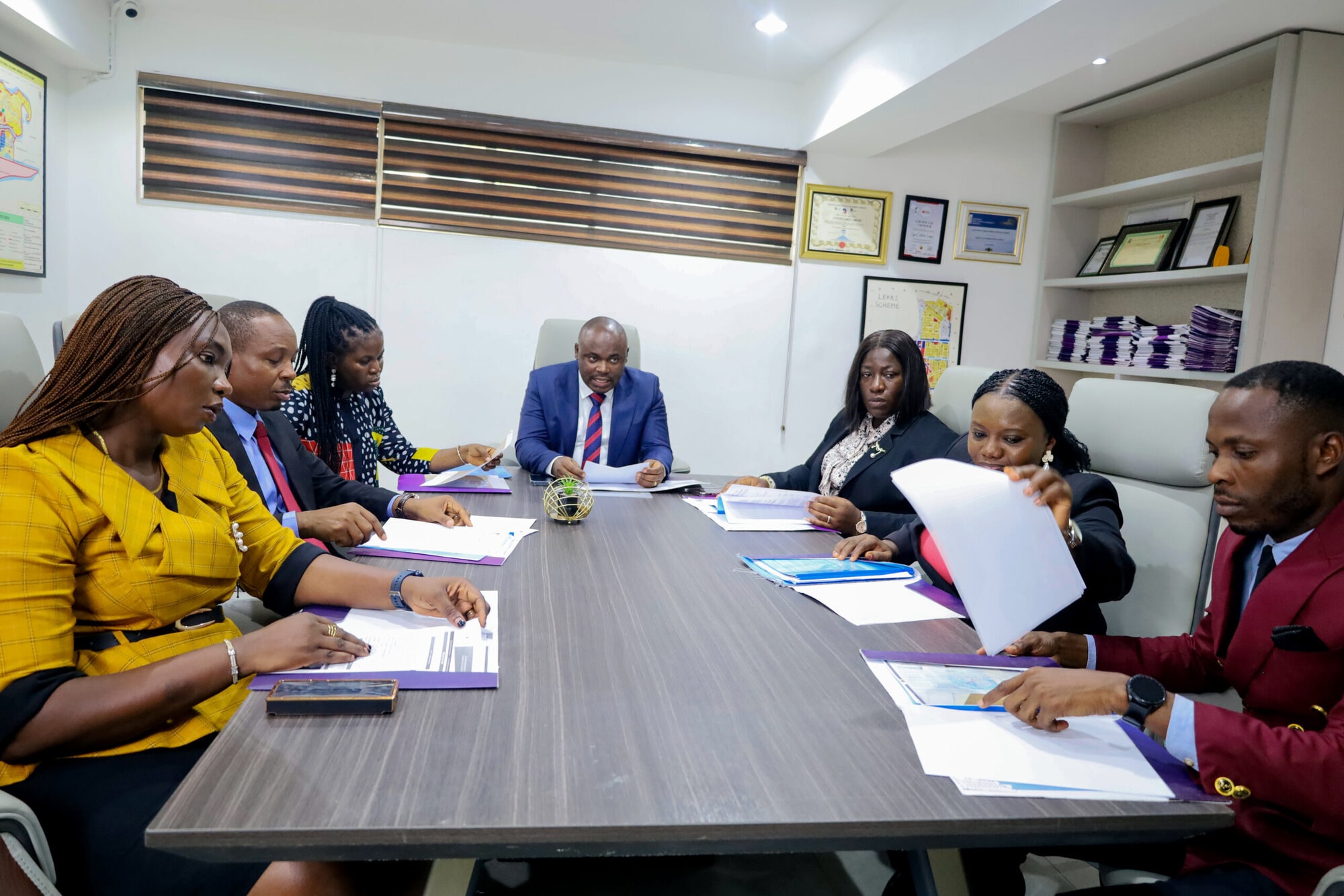 Efficacy leadership and team reviewing documents together around the boardroom table