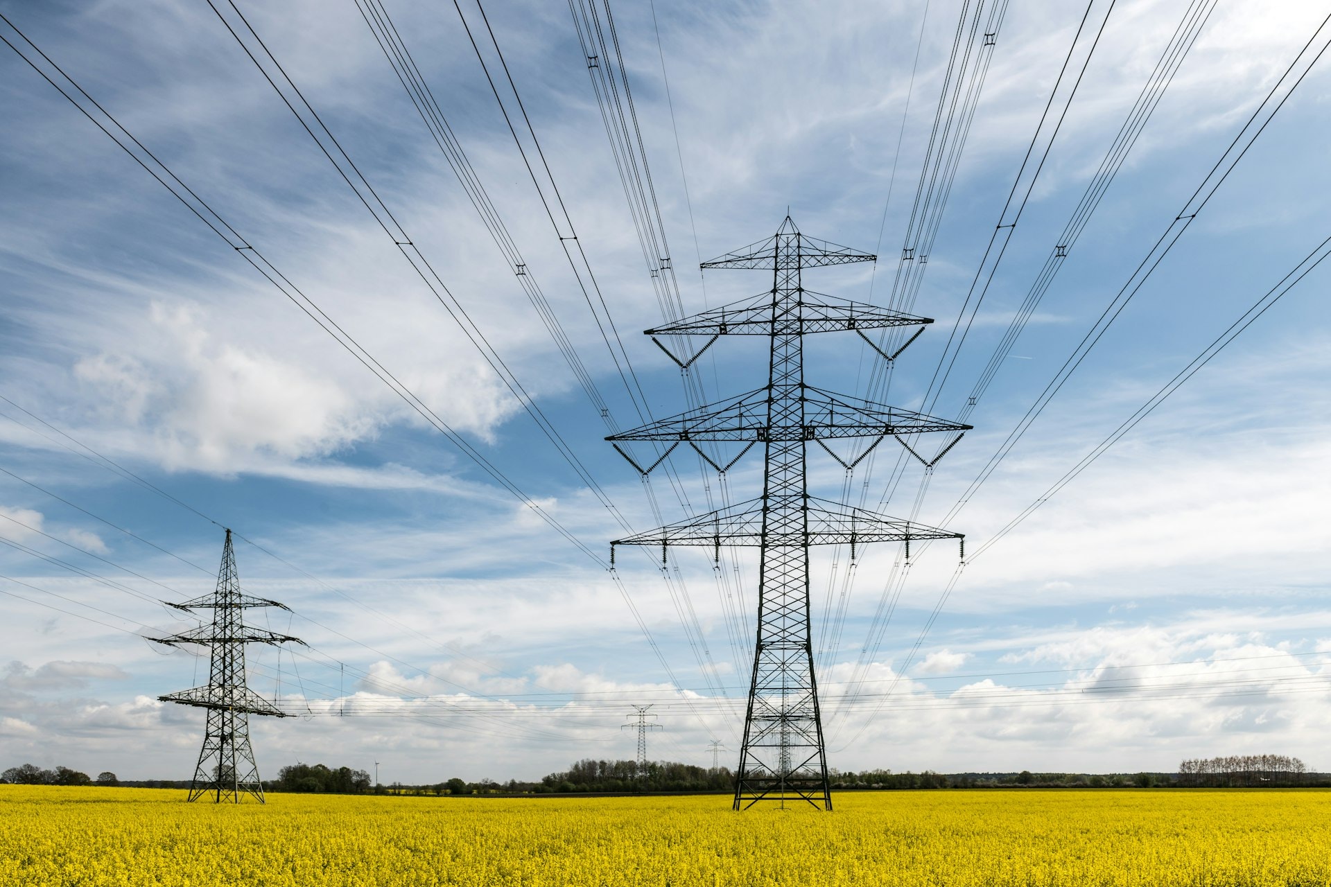 High-voltage transmission towers carrying power lines across open farmland
