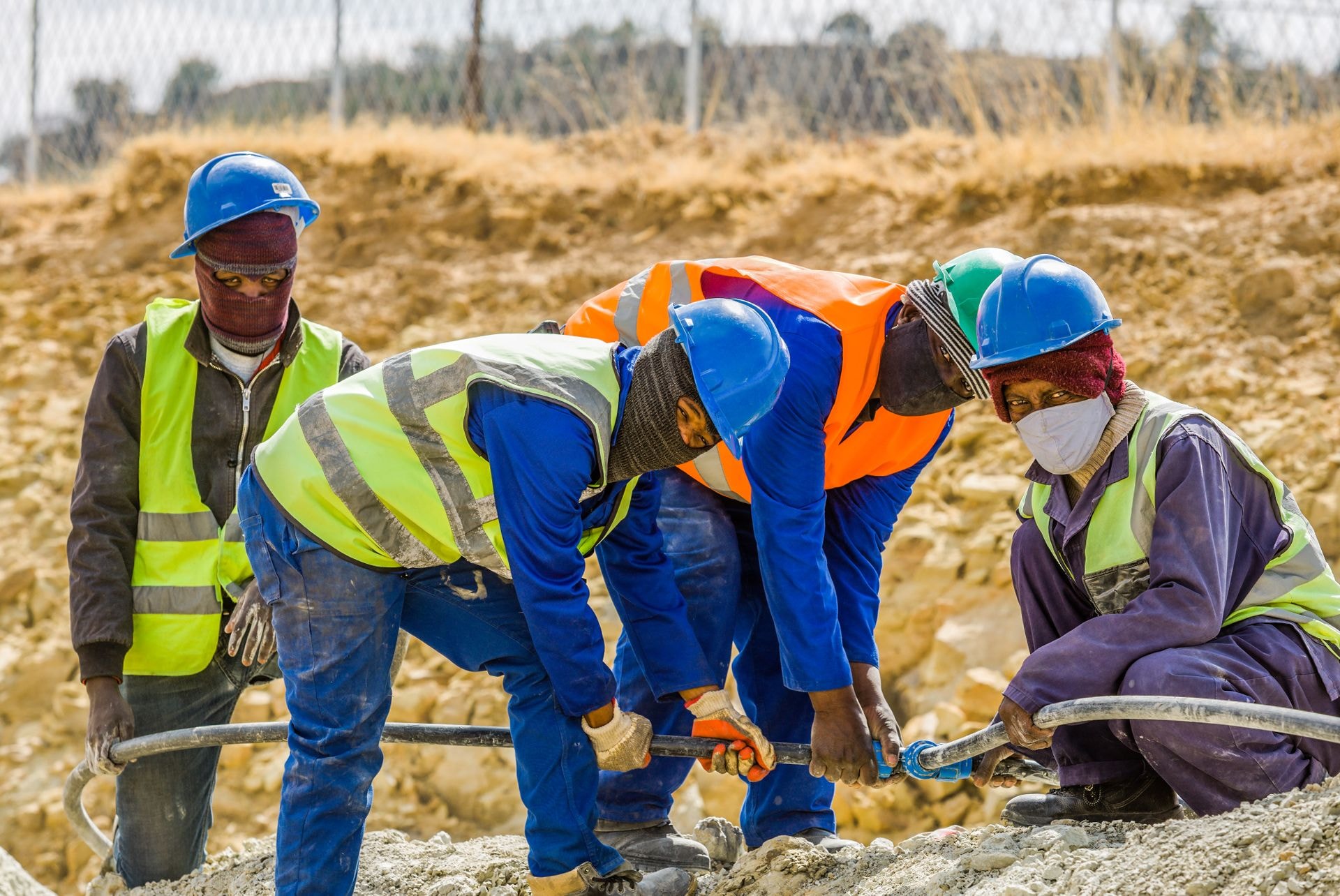 Construction crew in hard hats and high-visibility vests working together on site