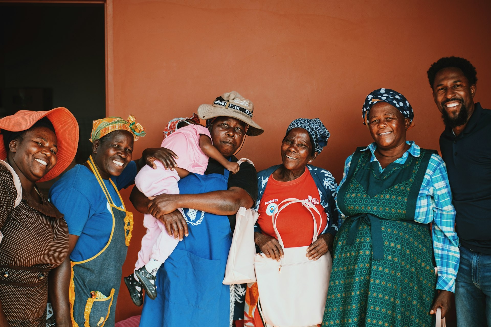 Members of a local community standing together and smiling
