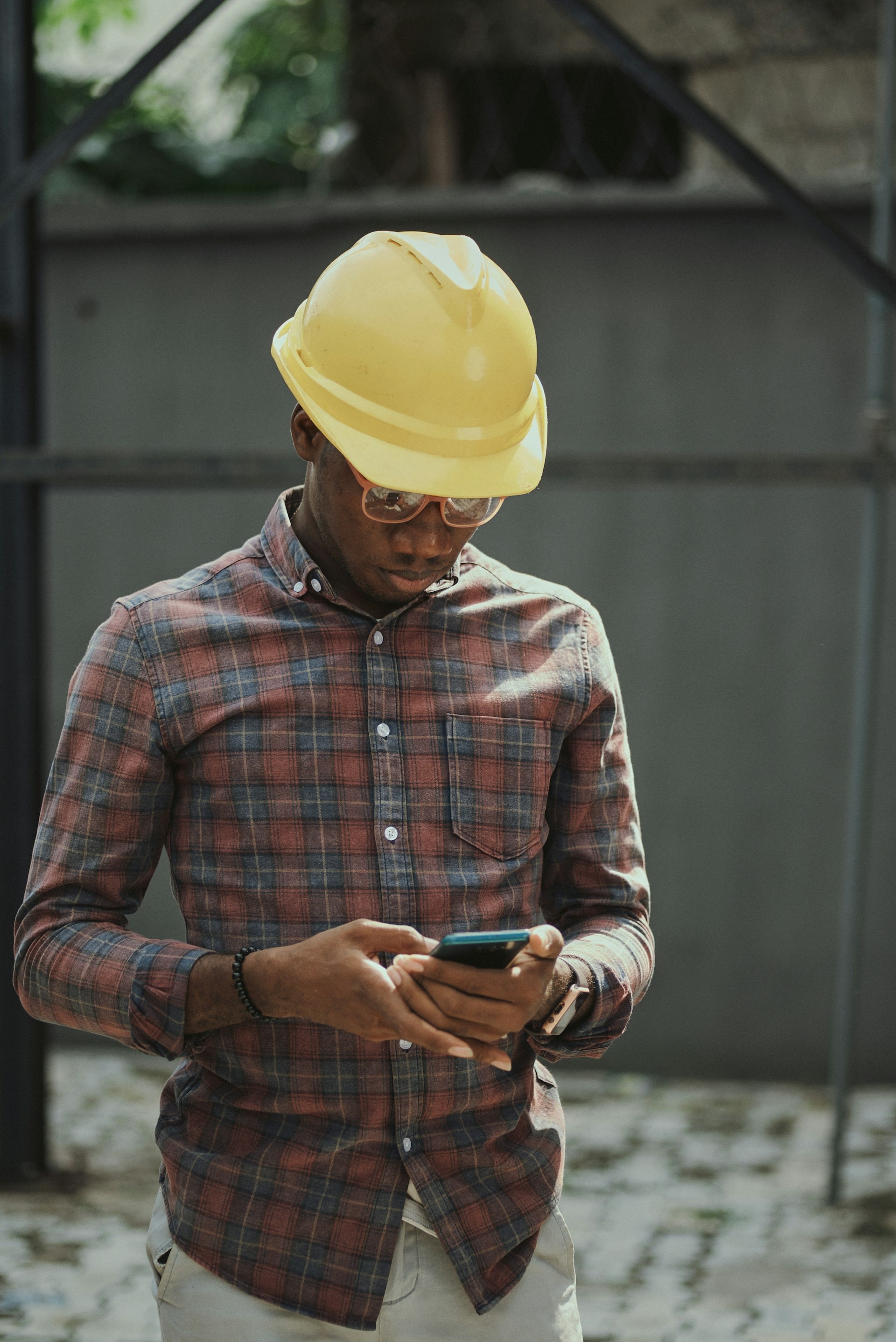 Construction professional in a hard hat using a smartphone on site