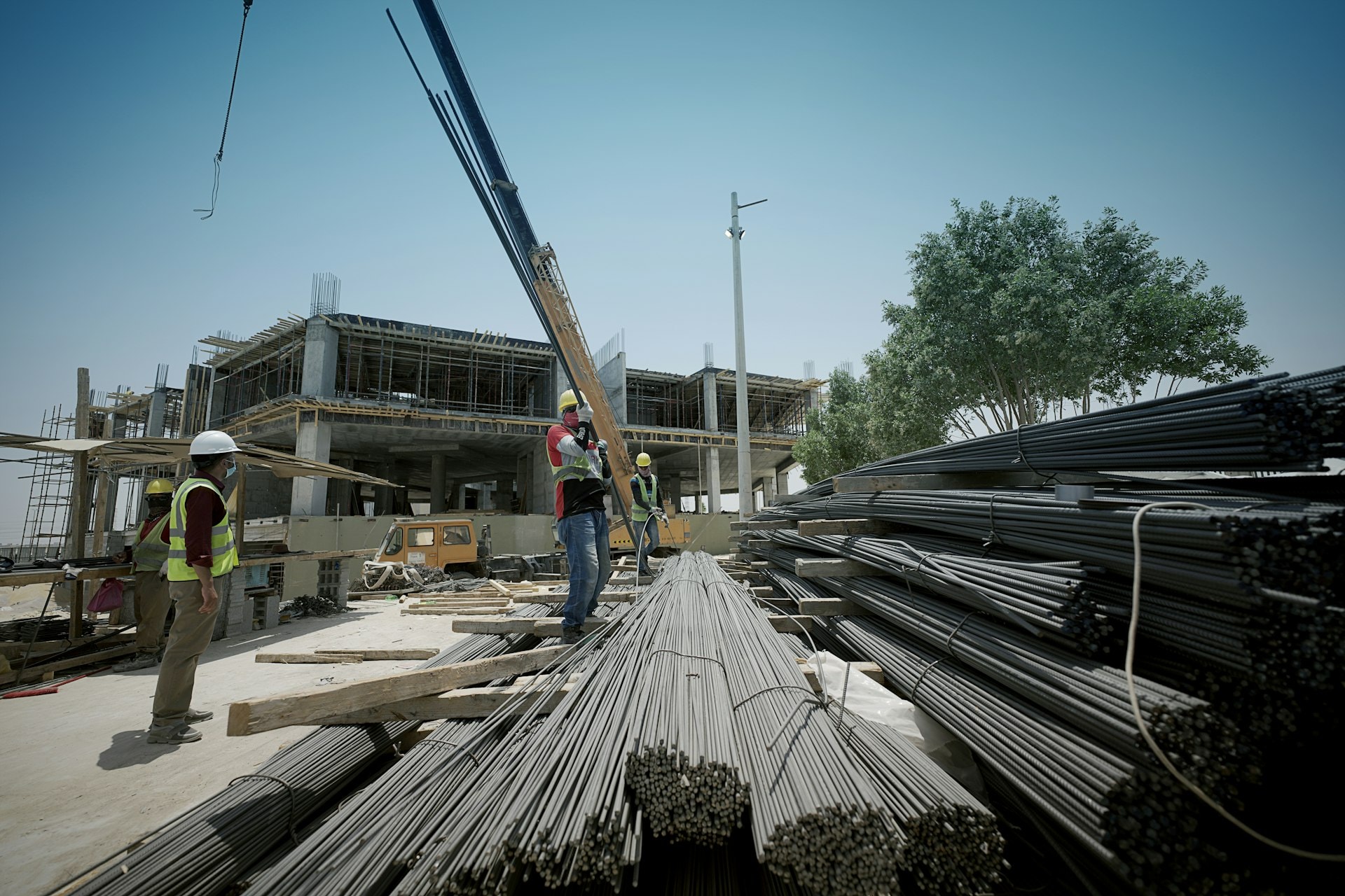 Crane lifting bundles of steel reinforcement bars delivered to a building site
